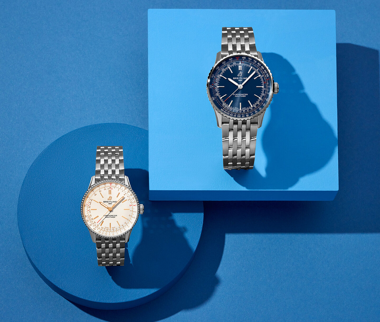 Deux montres Breitling Navitimer sur un fond bleu.